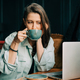 Young business woman drinking coffee while working on a laptop in a cafe. - PhotoDune Item for Sale