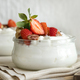 Greek yogurt, nuts and strawberries in a glass jars on a white table close up, copy space - PhotoDune Item for Sale