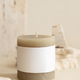 Candle with label on beige near cream travertine stones, Close up. Packaging mock up - PhotoDune Item for Sale