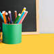 School supplies with books and chalk board on yellow background - PhotoDune Item for Sale