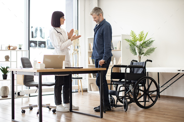Surgeon applauding man with cane needing no wheelchair - Stock Photo - Images