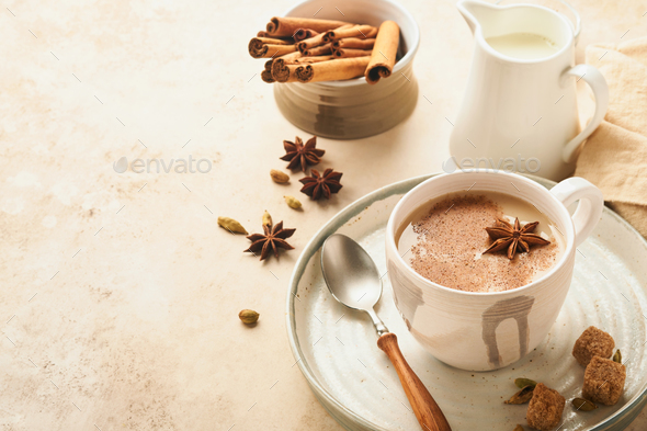 Masala tea. Masala chai spiced tea with milk and spices on light warm beige background. Traditional