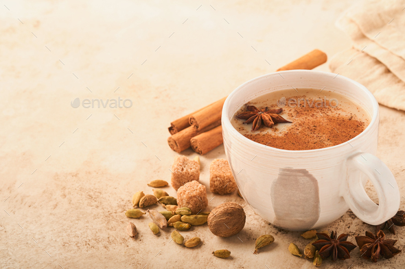Masala tea. Masala chai spiced tea with milk and spices on light warm beige background. Traditional