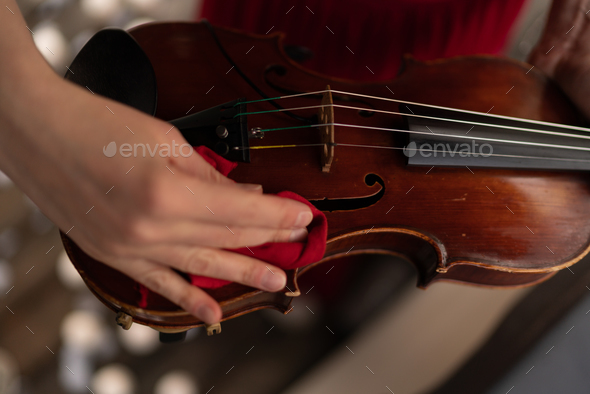 The woman cleans the violin - Stock Photo - Images