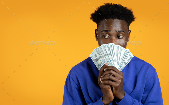 Black guy cover mouth with money cash, copy space