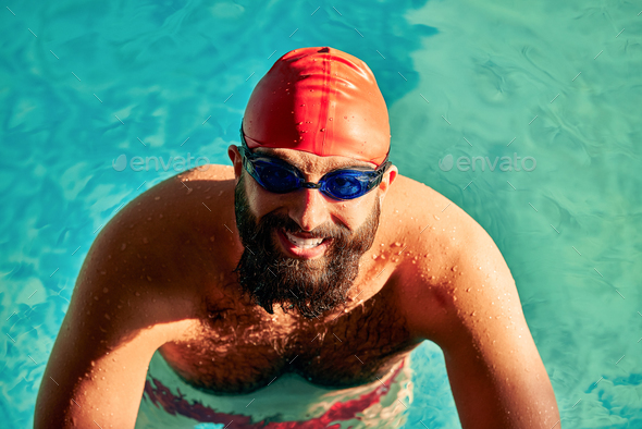 Male swimmer wearing a swimming hat at the pool