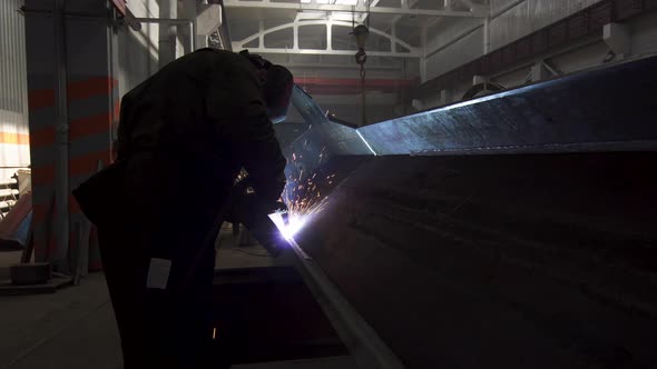 Manual Metal Welding, Spark Flow on Dark Background. Industrial Production. Protective Masked Welder alt