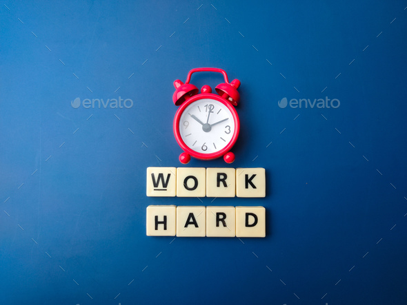 Red alarm clock and toys word with word WORK HARD. - Stock Photo - Images