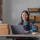 Happy young asian woman startup small business freelance holding parcel box and computer laptop and - PhotoDune Item for Sale