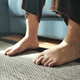 Woman sitting on sofa with feet on carpet at home. - PhotoDune Item for Sale