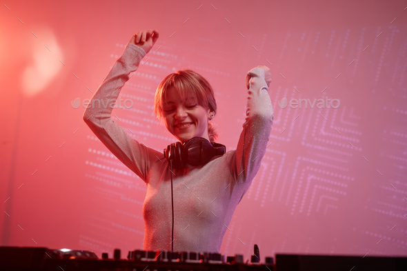 Young woman as female DJ at disco party in neon light