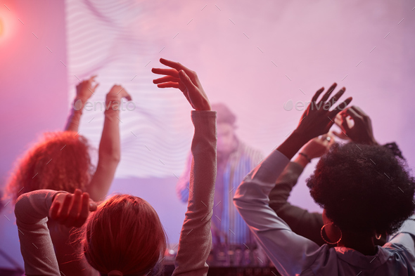 People dancing in neon lights at nightclub - Stock Photo - Images