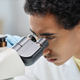 Ethnic man as scientist looking in microscope in laboratory - PhotoDune Item for Sale