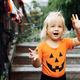 Lifestyle portrait of Happy caucasian baby girl with blonde hair in black orange costume celebrating - PhotoDune Item for Sale