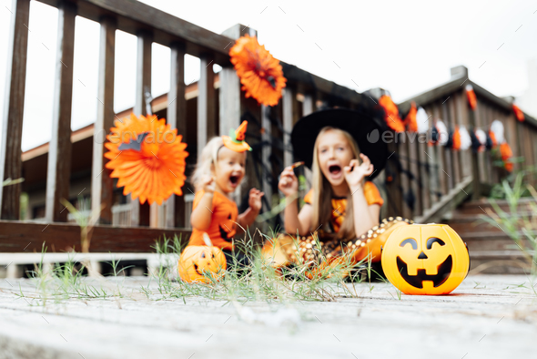 Lifestyle portrait of Happy Little caucasian siblings with blonde hair in black orange costume of - Stock Photo - Images