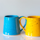 Close-up of yellow and blue ceramic cups. - PhotoDune Item for Sale