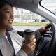 Chinese woman driving a car and holding a cup of coffee - PhotoDune Item for Sale