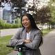 Portrait of Chinese woman riding on electric scooter in business outfit - PhotoDune Item for Sale
