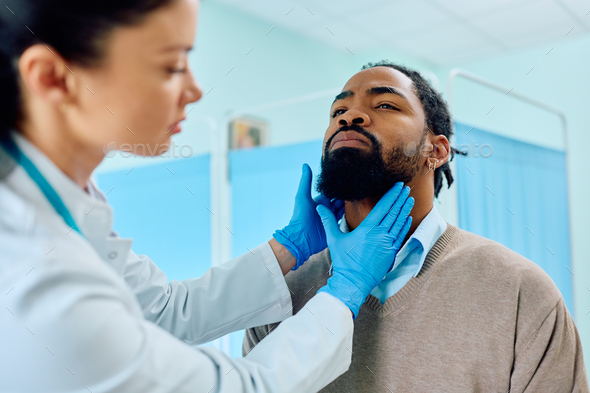 Black man having throat exam at doctor\'s office.