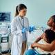 Female pediatrician talking to black mother and son in medical examination room. - PhotoDune Item for Sale