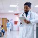 Black male doctor using digital tablet at the clinic. - PhotoDune Item for Sale
