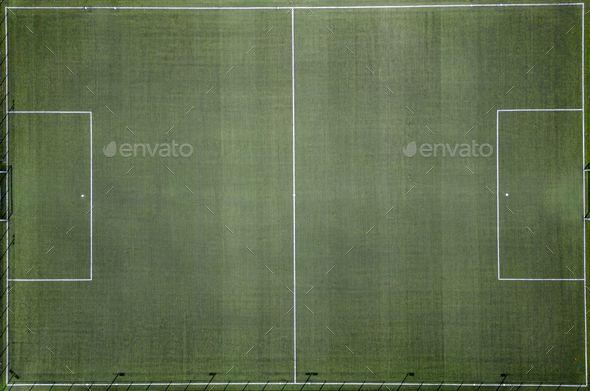 From an aerial perspective, an empty football field comes into view. The neatly mowed grass and the - Stock Photo - Images