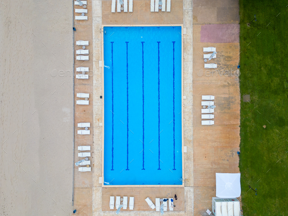 An aerial view reveals an empty pool, devoid of swimmers. The calm water reflects the surroundings - Stock Photo - Images