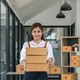 Woman startup small business entrepreneur works with boxes in a her workplace. Ecommerce business - PhotoDune Item for Sale