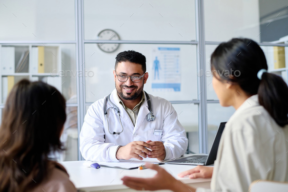 Pediatrician talking to parent and child - Stock Photo - Images