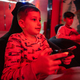 Two boys gamers play gamepad video game console in red gaming room. - PhotoDune Item for Sale