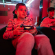 Two boys gamers play gamepad video game console in red gaming room. - PhotoDune Item for Sale