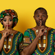 Beautiful black couple in african costumes showing silence gesture - PhotoDune Item for Sale