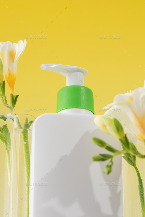 A dispenser with a cosmetic skin care product for the face and body flowers. Close up - Stock Photo - Images