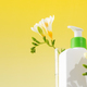 A mockup of a dispenser with a cosmetic skin care product with flowers. Copy space - PhotoDune Item for Sale