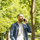 Young man talking on phone while walking in a park. - PhotoDune Item for Sale