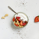 Greek yogurt, nuts and strawberries in a glass jar with a spoon on a white table top view - PhotoDune Item for Sale
