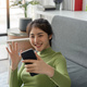 Attractive woman having video call on the phone on the sofa - PhotoDune Item for Sale
