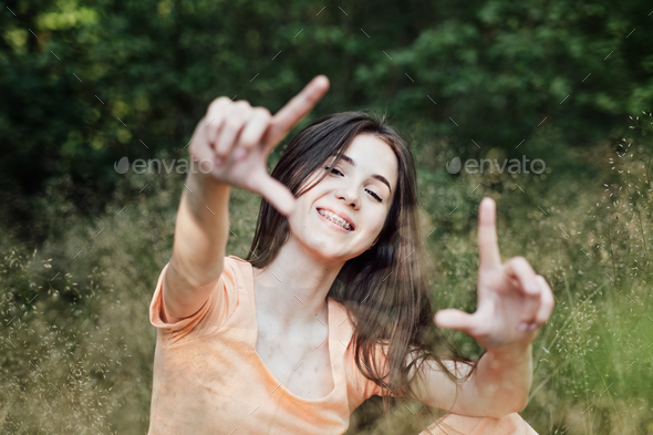 Candid portrait of beautiful happy smiling young woman with braces in summer park. Outdoor portrait - Stock Photo - Images