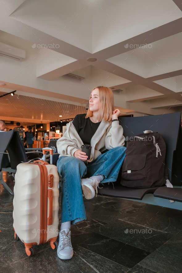 Travel.young woman at airport at window with suitcase waiting for plane, girl waiting for departure  - Stock Photo - Images
