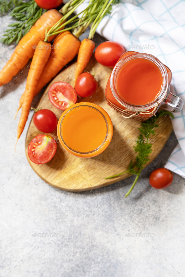 Tomato and carrot juice in a glasses on a stone table. Vitamins drinks juice carrot and tomato. - Stock Photo - Images