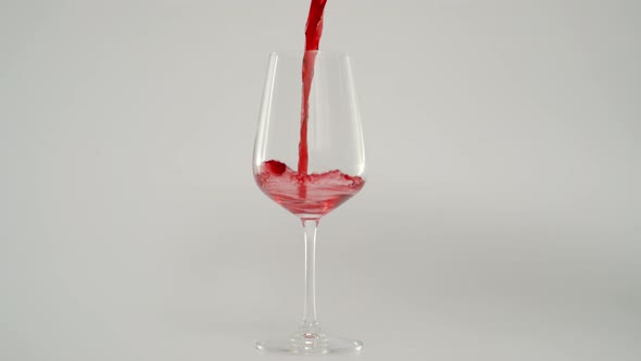 Slow Motion of Pouring Red Wine in Glass at 1000 Fps Red Background alt