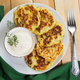 Vegan green zucchini pancakes in plate and creamy sauce. Healthy vegan diet food. - PhotoDune Item for Sale