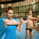 Young woman instructor exercising retired man before training in swimming pool - PhotoDune Item for Sale