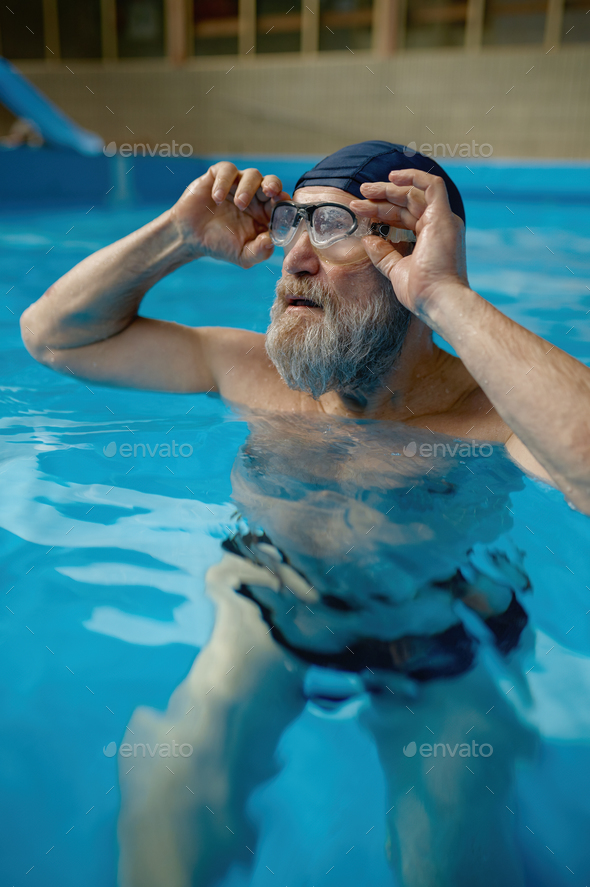 Healthy senior man swimming in indoor pool enjoying sportive lifestyle - Stock Photo - Images