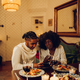 African american couple having romantic date and using smartphone at home - PhotoDune Item for Sale