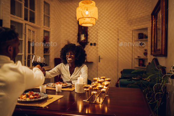 Portrait of an african american woman having a romantic date at home with her boyfriend - Stock Photo - Images