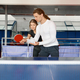 Adult woman instructor teaching male student to play table tennis at sport club - PhotoDune Item for Sale