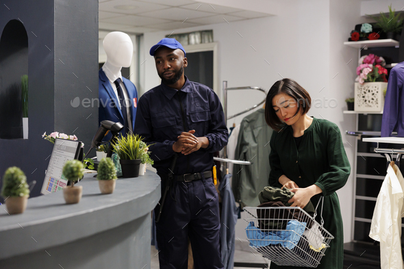 Security guard working in clothes store - Stock Photo - Images