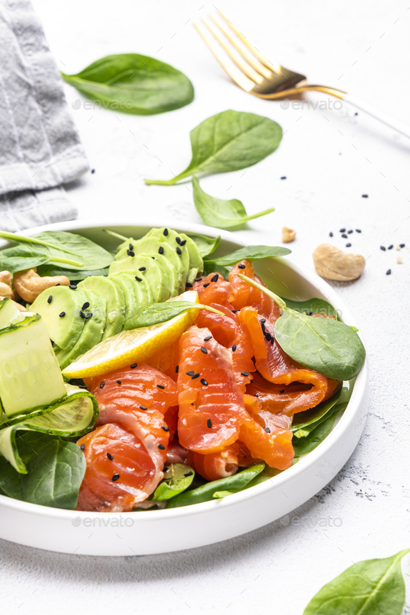 Keto salad with salmon, avocado, spinach, cucumber, sesame seeds  and cashew nuts - Stock Photo - Images