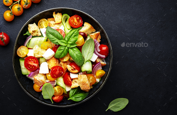 Panzanella salad with stale bread, colorful tomatoes, mozzarella, onion, olive oil and green basil - Stock Photo - Images